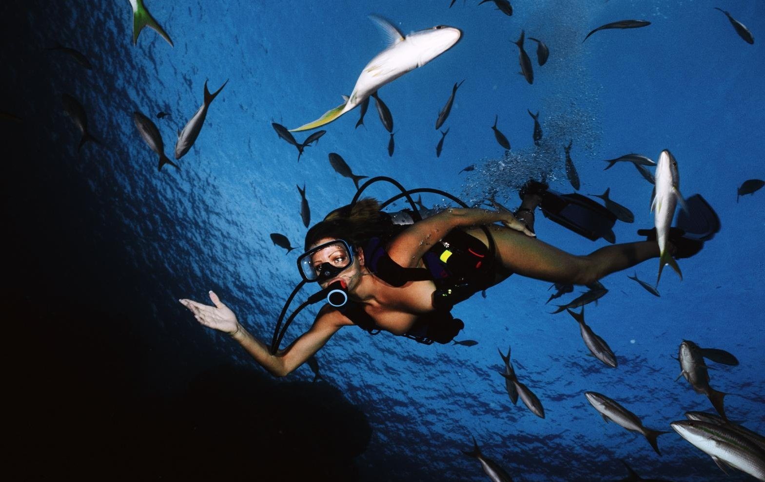 Голая девушка дайвер с аквалангом под водой на морском дне